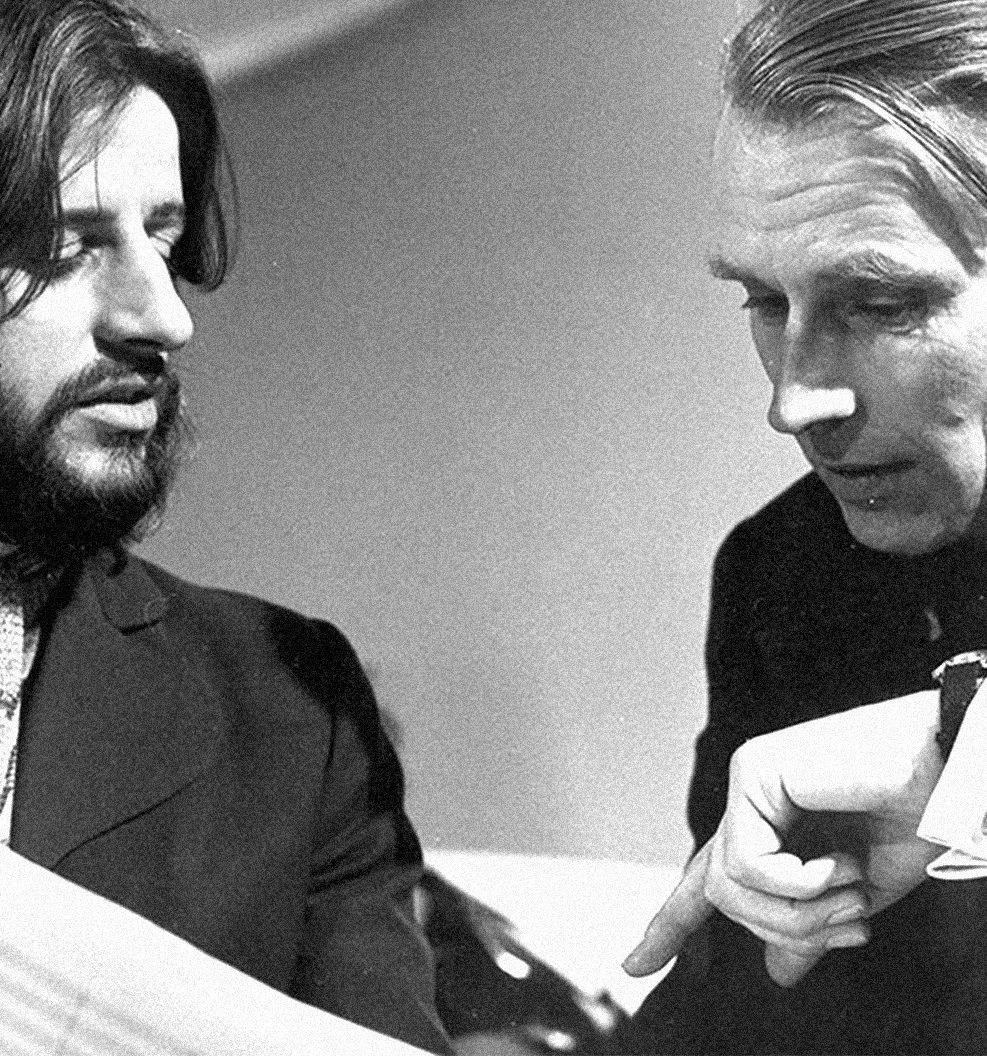 Ringo Starr and producer George Martin go over sheet music in the studio