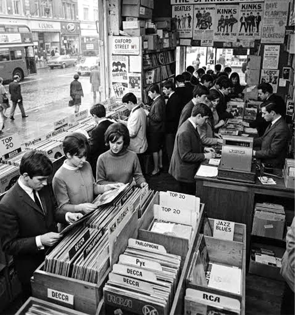 Teenagers flip through the record bins in a crowded 1960s record shop